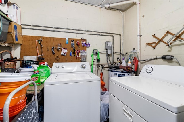 clothes washing area featuring washing machine and dryer and a workshop area