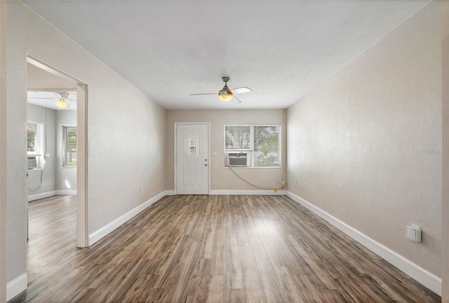 spare room with cooling unit, ceiling fan, and hardwood / wood-style flooring