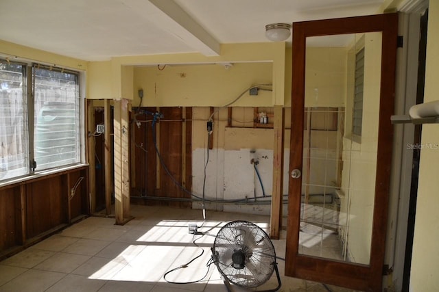 interior space with beam ceiling and light tile patterned flooring