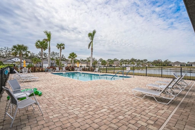 view of swimming pool with a patio area and a water view