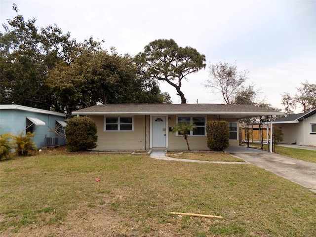 ranch-style home featuring central AC unit, a front yard, and a carport