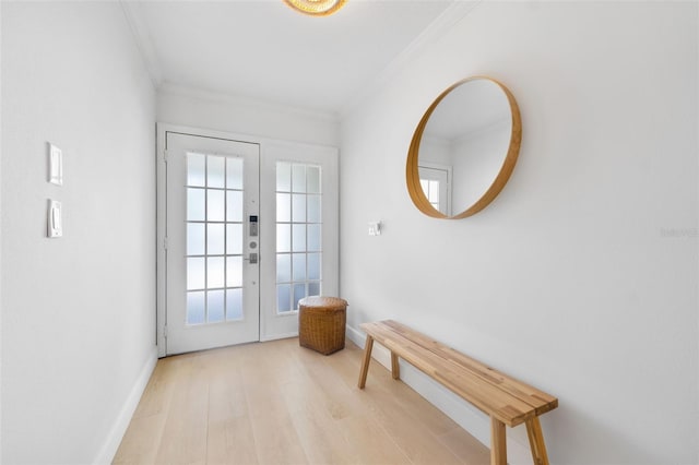 entryway with french doors, crown molding, and light hardwood / wood-style flooring