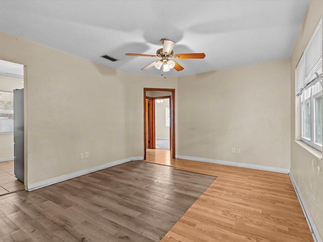 empty room with light wood-type flooring and ceiling fan