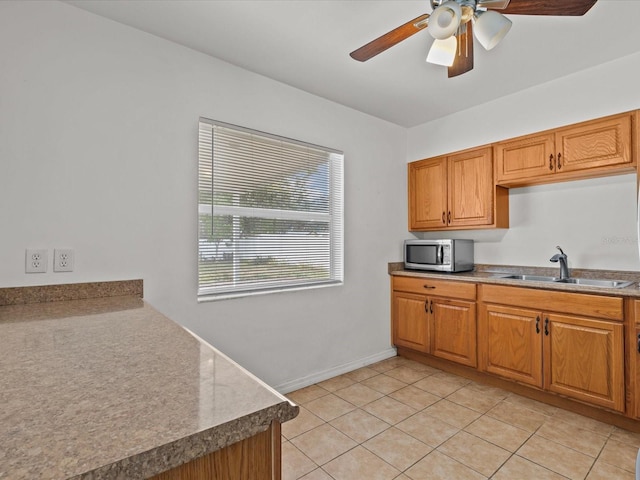 kitchen featuring ceiling fan, light tile patterned flooring, and sink