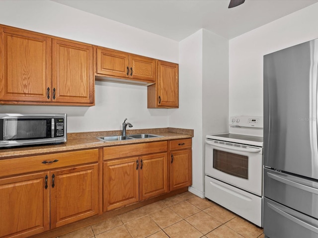 kitchen with appliances with stainless steel finishes, sink, and light tile patterned floors