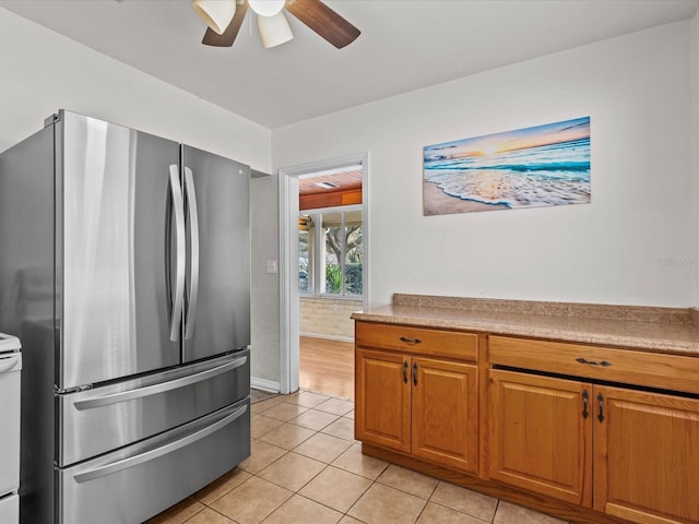 kitchen featuring stainless steel refrigerator, white range with electric stovetop, ceiling fan, and light tile patterned floors