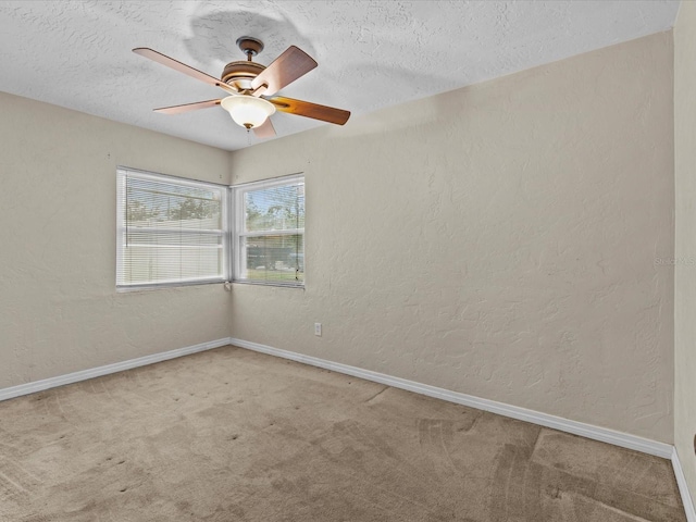 carpeted empty room featuring a textured ceiling and ceiling fan