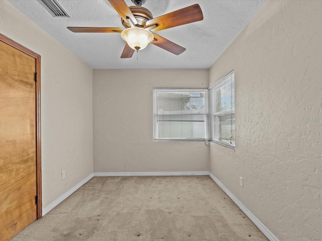 carpeted empty room with a textured ceiling and ceiling fan