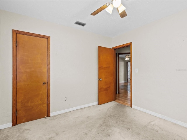 unfurnished bedroom featuring light carpet and ceiling fan