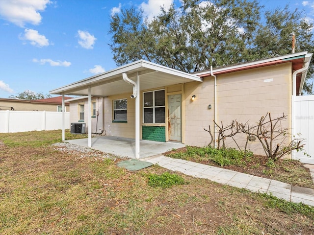 ranch-style home featuring central AC, a patio area, and a front lawn