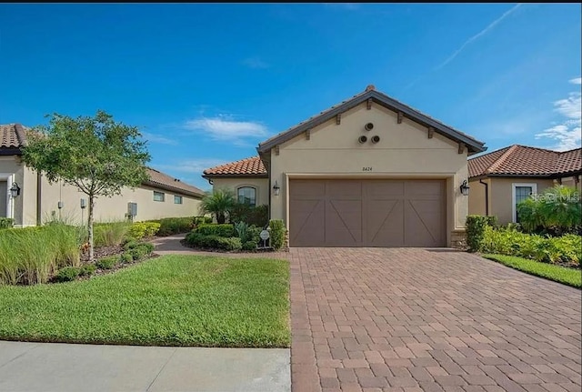 mediterranean / spanish house featuring a front lawn and a garage