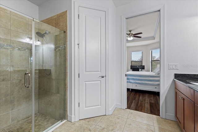 bathroom with ceiling fan, tile patterned floors, a shower with door, and vanity