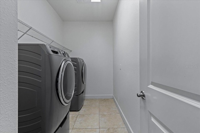 washroom featuring light tile patterned flooring and washer and dryer