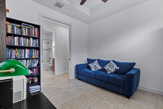 sitting room featuring ceiling fan, light tile patterned floors, and ornamental molding