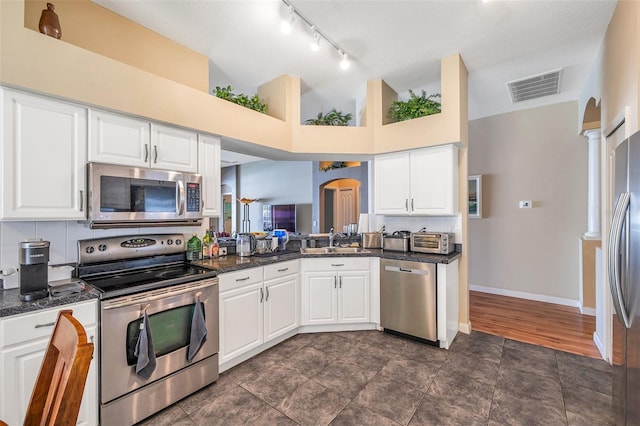 kitchen featuring white cabinets, appliances with stainless steel finishes, sink, and ornate columns