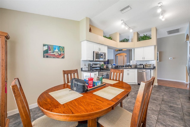 dining room featuring a towering ceiling and sink