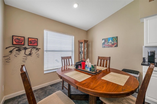 tiled dining room featuring lofted ceiling