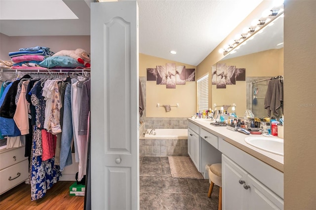 bathroom with lofted ceiling, vanity, a textured ceiling, and shower with separate bathtub