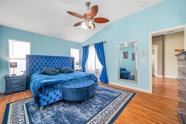 bedroom with ceiling fan, wood-type flooring, multiple windows, and lofted ceiling