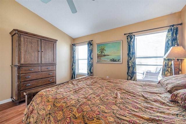 bedroom featuring ceiling fan, light wood-type flooring, and lofted ceiling