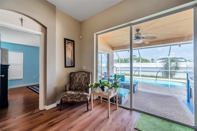 living area featuring vaulted ceiling, ceiling fan, and wood-type flooring