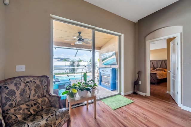 living area featuring light hardwood / wood-style floors and ceiling fan