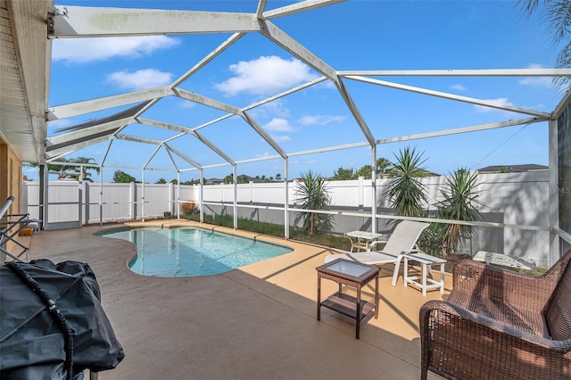 view of pool with glass enclosure and a patio area