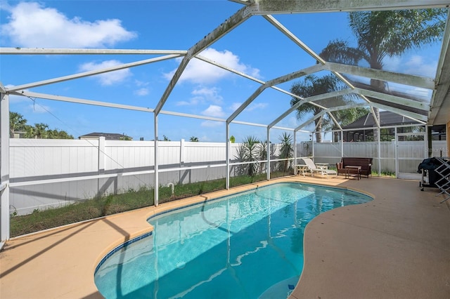 view of swimming pool with glass enclosure and a patio