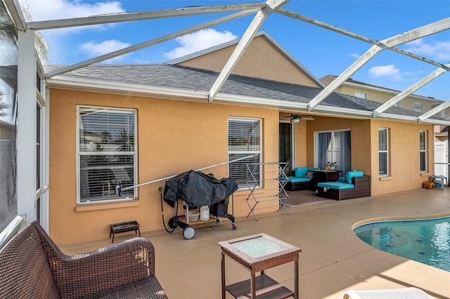 rear view of property featuring a patio area, ceiling fan, glass enclosure, and an outdoor hangout area