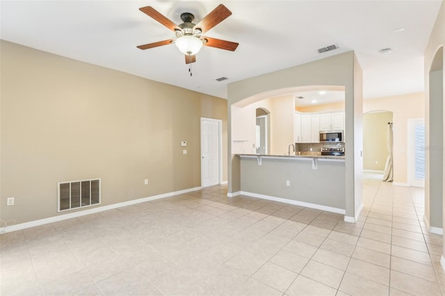 unfurnished living room with light tile patterned flooring and ceiling fan