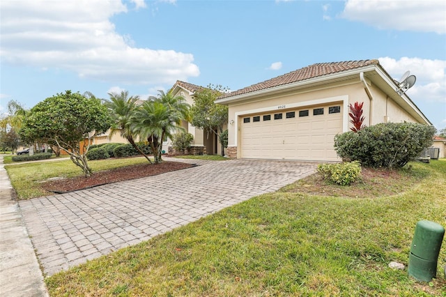 view of front of house featuring central AC unit, a garage, and a front lawn