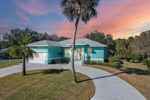 view of front of property with a lawn and a garage