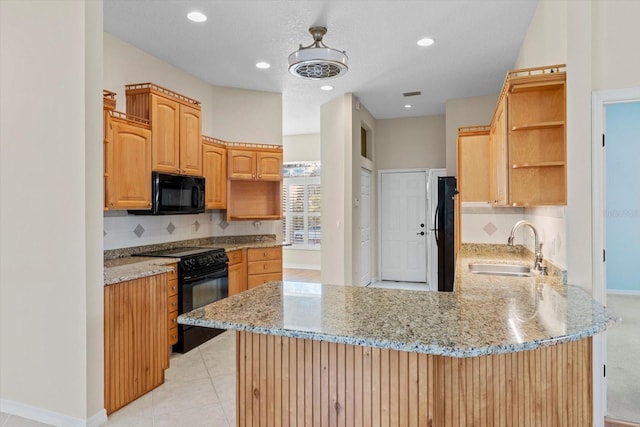 kitchen featuring kitchen peninsula, light stone countertops, black appliances, light tile patterned flooring, and sink