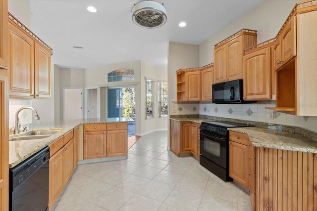 kitchen featuring black appliances, sink, light stone countertops, and kitchen peninsula