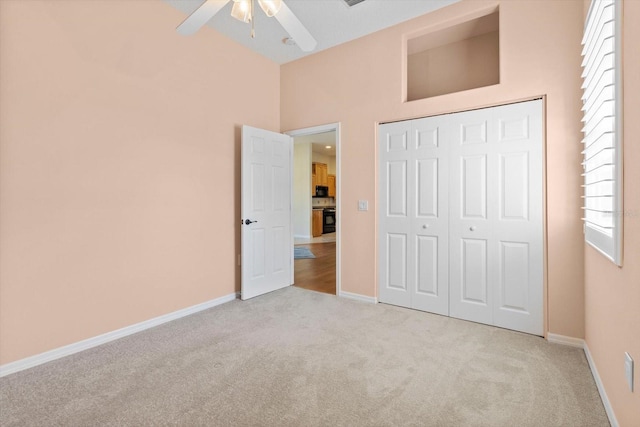 unfurnished bedroom featuring light colored carpet, ceiling fan, and a closet