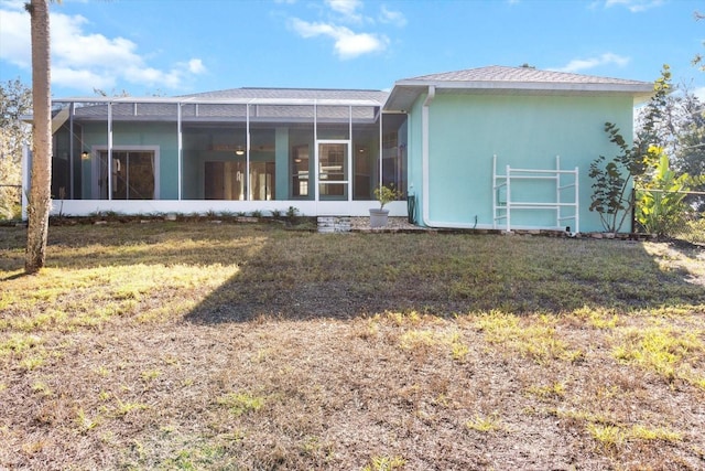 rear view of house with a lanai and a yard