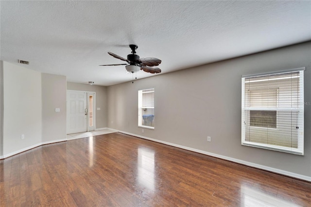 empty room with ceiling fan, a textured ceiling, and wood-type flooring