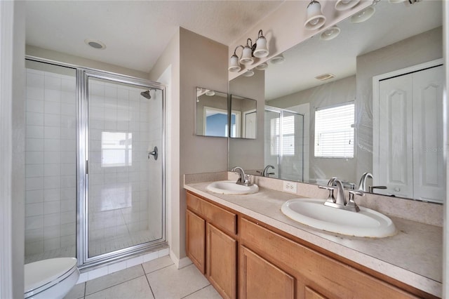 bathroom with a shower with door, toilet, tile patterned flooring, and vanity