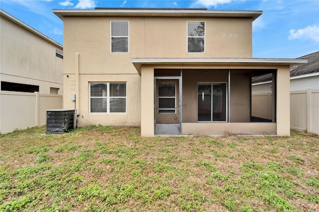 rear view of house featuring a yard, a sunroom, and central AC unit