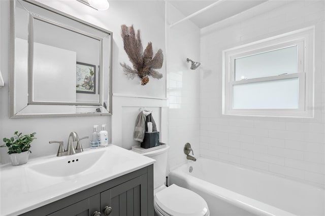 full bathroom featuring tiled shower / bath combo, vanity, and toilet