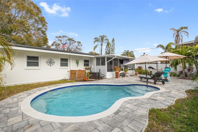 view of swimming pool with a sunroom and a patio