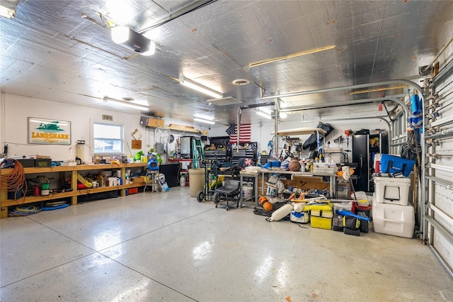 garage featuring a garage door opener and a workshop area