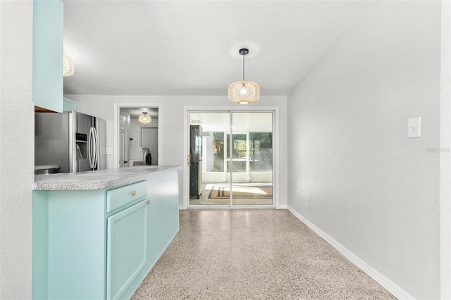 kitchen with decorative light fixtures, stainless steel fridge, and separate washer and dryer