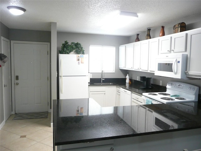 kitchen with light tile patterned floors, white appliances, a textured ceiling, white cabinets, and sink