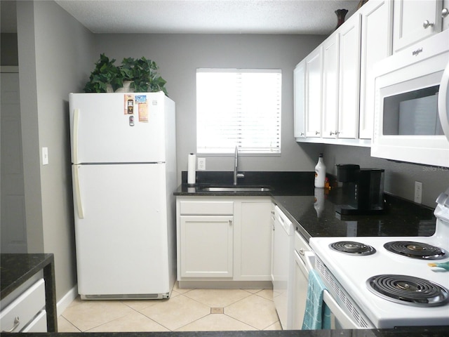 kitchen with sink, white appliances, white cabinets, and a textured ceiling