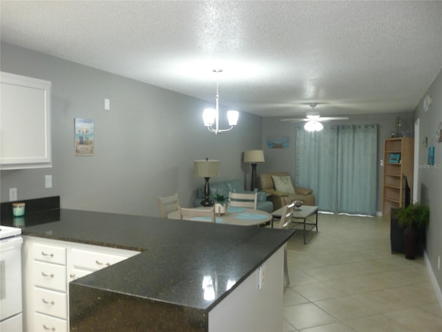 kitchen with white cabinetry, decorative light fixtures, white electric range, a textured ceiling, and ceiling fan with notable chandelier