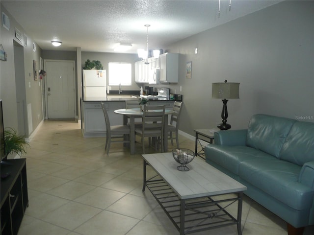 living room featuring sink, a textured ceiling, and a notable chandelier