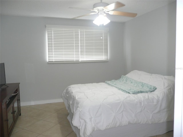 bedroom with ceiling fan and light tile patterned floors