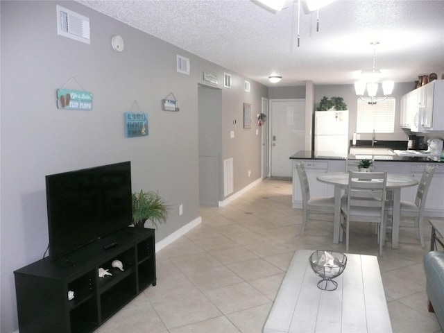 6033 34th St W Unit 45, Bradenton, FL 34210 - living area with a textured ceiling, light tile patterned floors, a chandelier, baseboards, and ceiling fan
