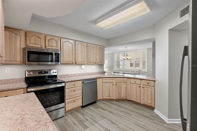 kitchen with a chandelier, appliances with stainless steel finishes, decorative light fixtures, and light brown cabinetry